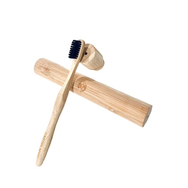 bamboo toothbrush resting on bamboo case