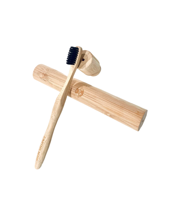 bamboo toothbrush resting on bamboo case